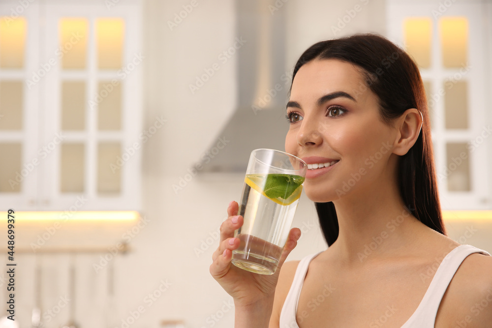Young woman with glass of fresh lemonade at home, space for text Young woman with glass of fresh lemonade at home, space for text