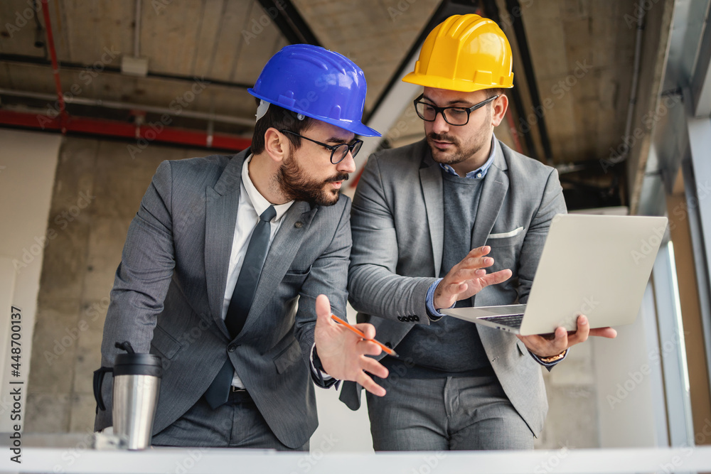 Two architect in building in construction process talking and brainstorming about innovations in their project. Two architect in building in construction process talking and brainstorming about innovations in their project.