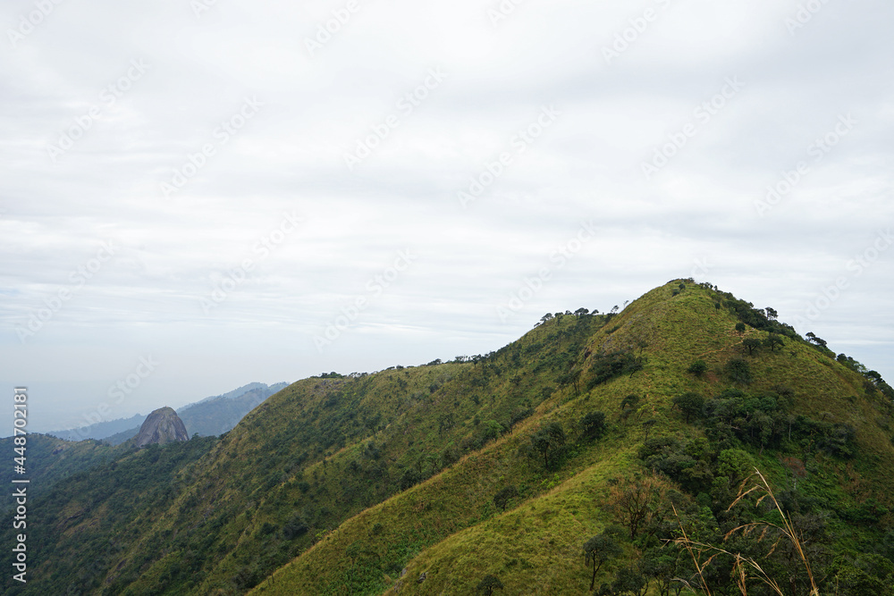 Natural landscape of green mountain range with cloudy blue sky Natural landscape of green mountain range with cloudy blue sky