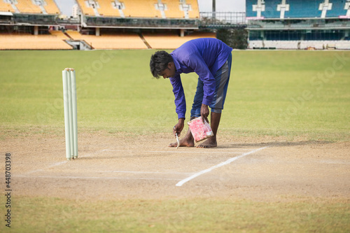 Groundsman making the crease before a match photo