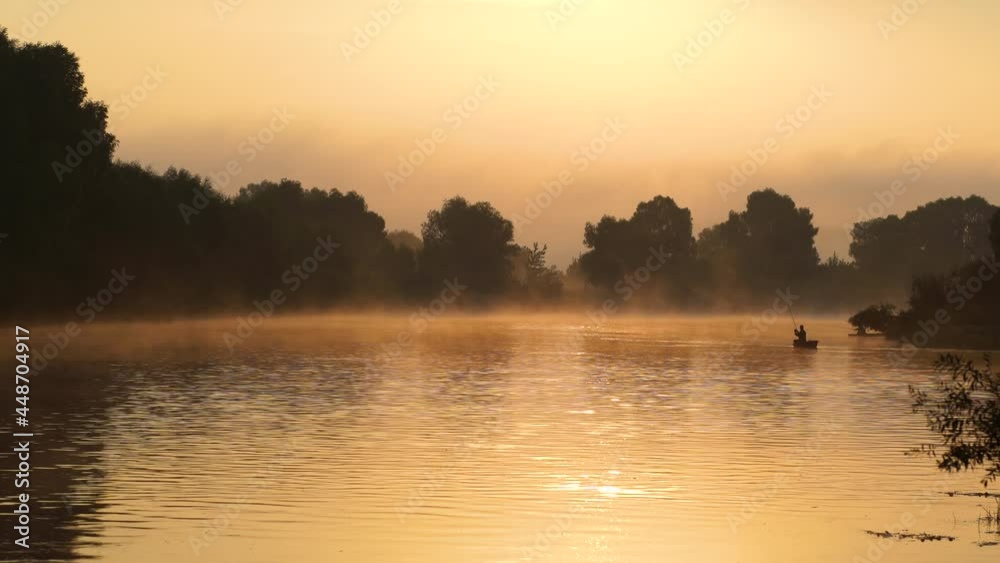 Beautiful dramatic early morning scenic sunrise countryside landscape. Black silhouettes of small boats and fishermen, cloudy foggy peaceful river, golden sky, trees reflected on surface of water Beautiful dramatic early morning scenic sunrise countryside landscape. Black silhouettes of small boats and fishermen, cloudy foggy peaceful river, golden sky, trees reflected on surface of water