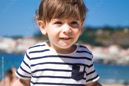 portrait of little boy in striped t-shirt on the beach