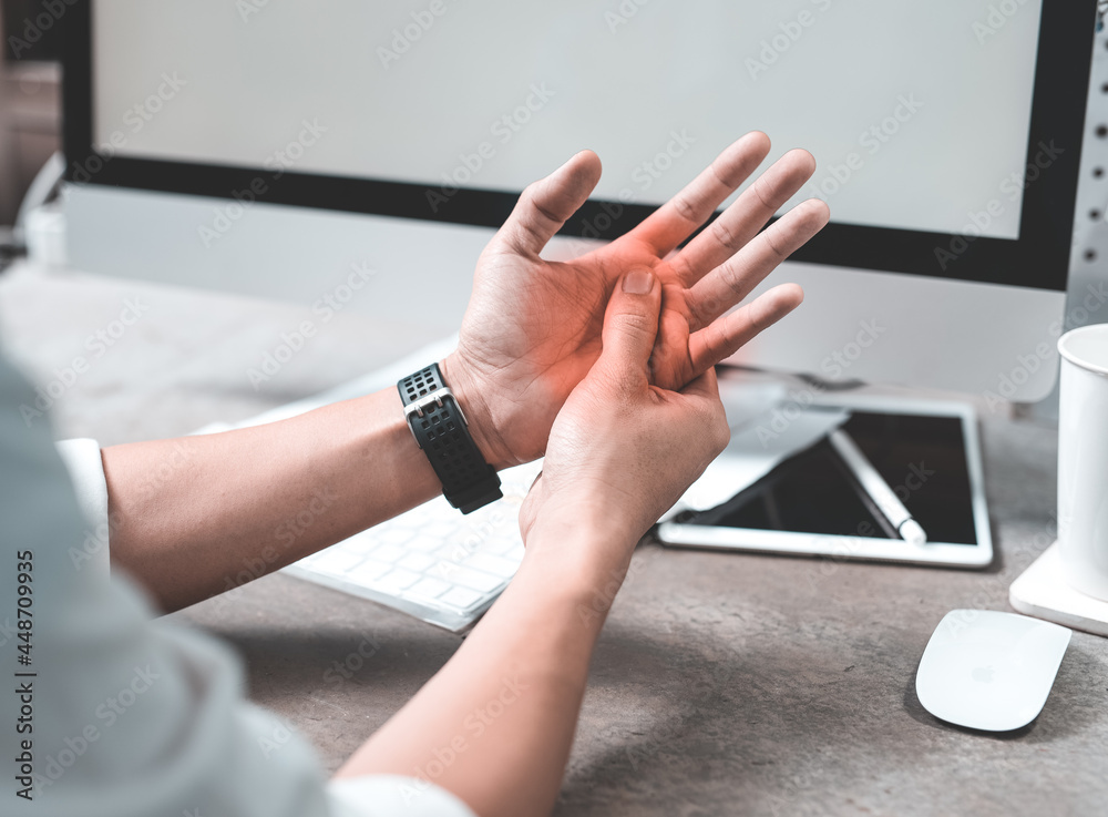 Man holding her hand pain from using computer long time,Office syndrome concept