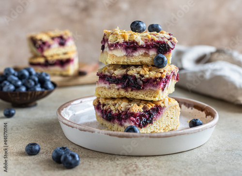 Foto Crumble cheesecake bars with blueberry filling and fresh blueberries, concrete background