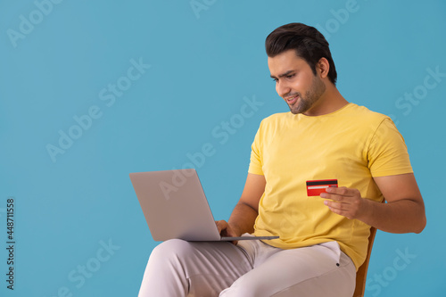 A young man making online payment with credit card and laptop. photo