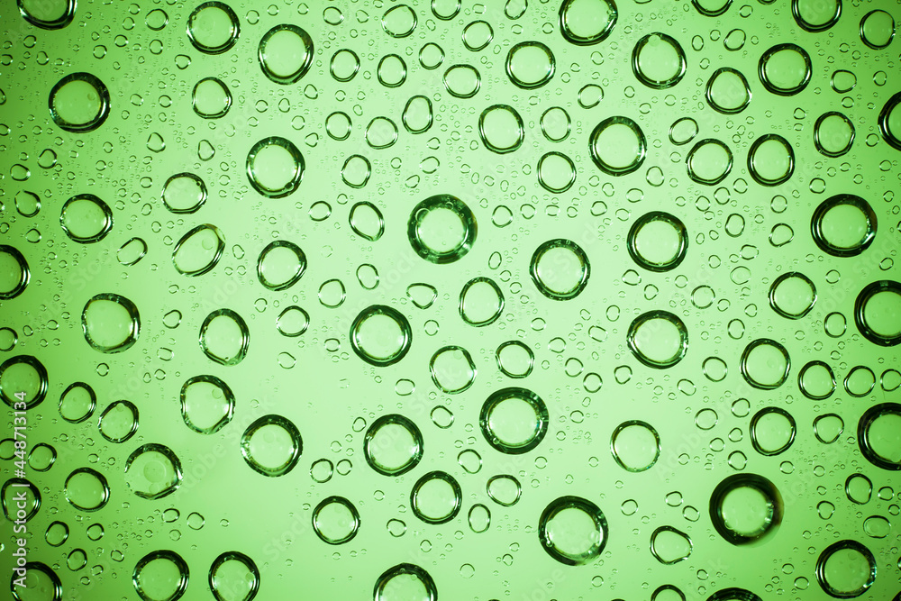 Water bubble on green glass.