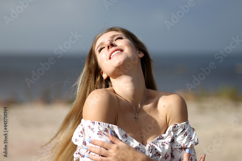 Young towheaded woman in white dress at the beach photo