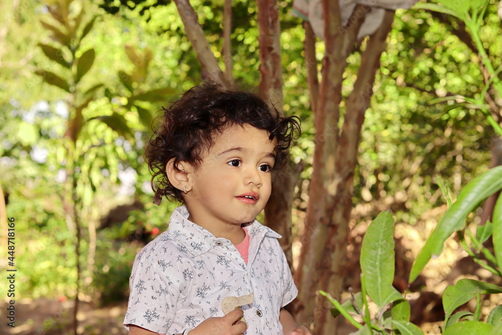 a small child standing in the garden thinking about Nature and eco a small child standing in the garden thinking about Nature and eco