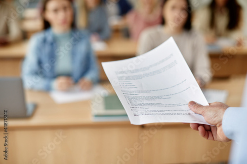 Close-up of unrecognizable university teacher gives lecture in classroom. photo