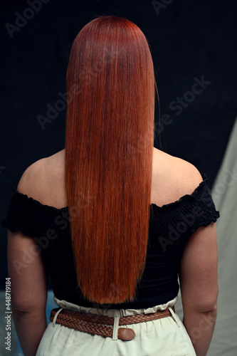 Red-haired model on a gray background. Back view