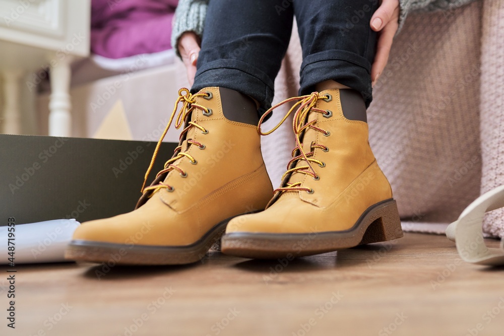 Autumn winter season, new shoes, close-up woman shoeing warm boots Autumn winter season, new shoes, close-up woman shoeing warm boots