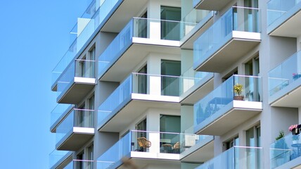 New apartment building with glass balconies. Modern architecture houses by the sea. Large glazing on the facade of the building.