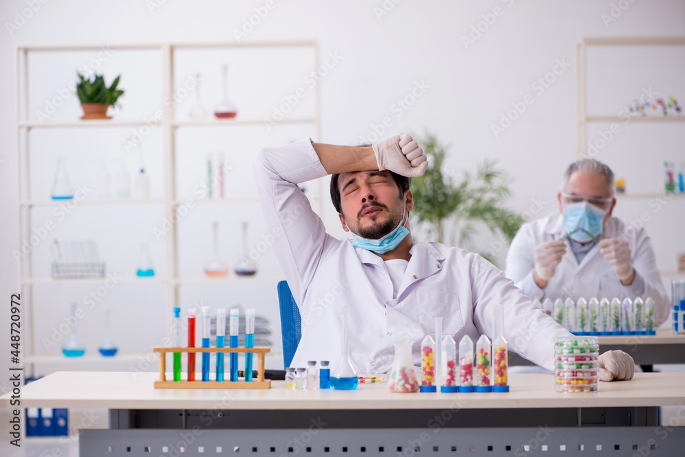 Two male chemists in drugs synthesis concept at the lab