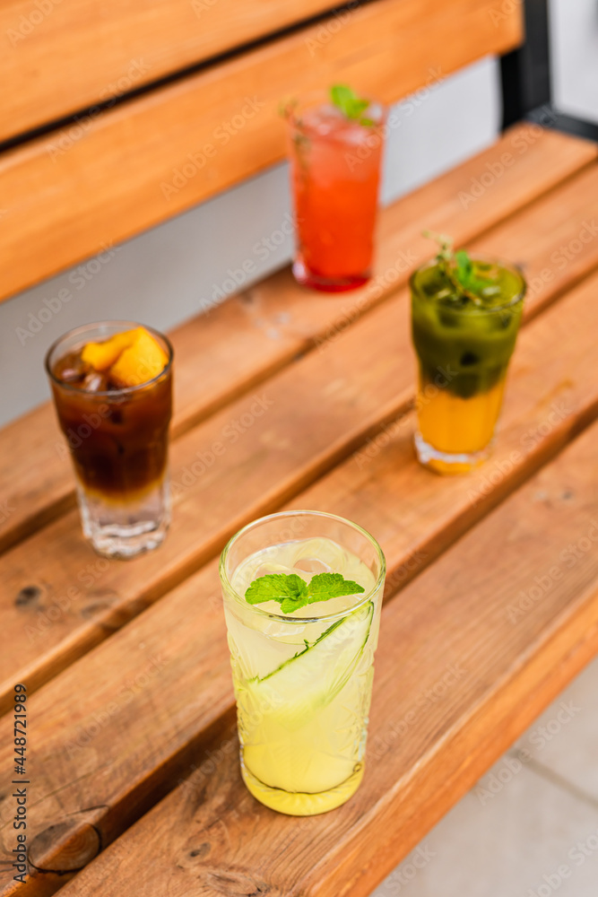 Fototapeta premium A variety of refreshing summer iced lemonades: espresso tonic, matcha tonic, ginger and pineapple, raspberry and passion fruit. Served in highball glasses.