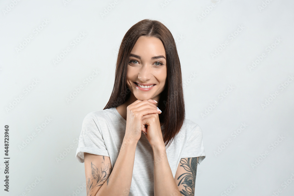 Portrait of pretty young woman with gorgeous chestnut hair and charming smile on light background Portrait of pretty young woman with gorgeous chestnut hair and charming smile on light background