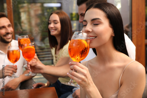 Sticker Friends spending time together, focus on young woman drinking Aperol spritz cock