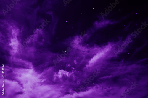 Purple night sky with fluffy clouds and stars. Fantastic sky background for design.