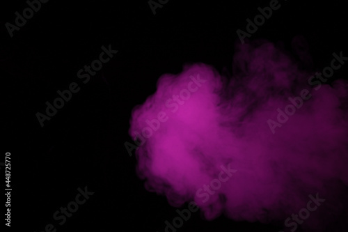 Colorful smoke close-up on a black background. Blurred pink cloud of smoke.