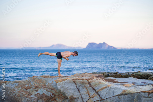 Tableau sur toile Hombre haciendo yoga en la playa