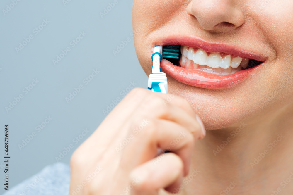 Woman with healthy white teeth holds a toothbrush and smiles. Oral hygiene concept Woman with healthy white teeth holds a toothbrush and smiles. Oral hygiene concept