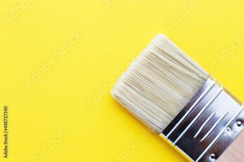 Paint brush isolated on a yellow background close with copy space