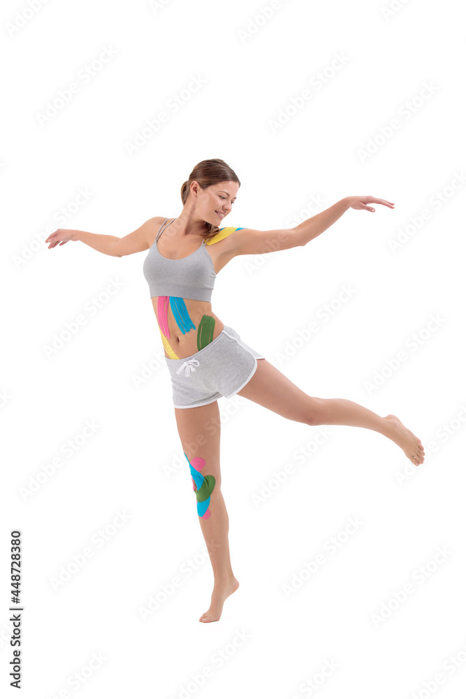 Woman showing kinesio tapes taped to her body. Full-length portrait of woman with Bright medical kinesio tapes