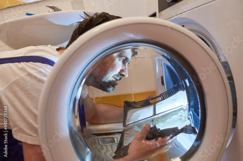 Handwerker beim Säubern vom Flusensieb photo