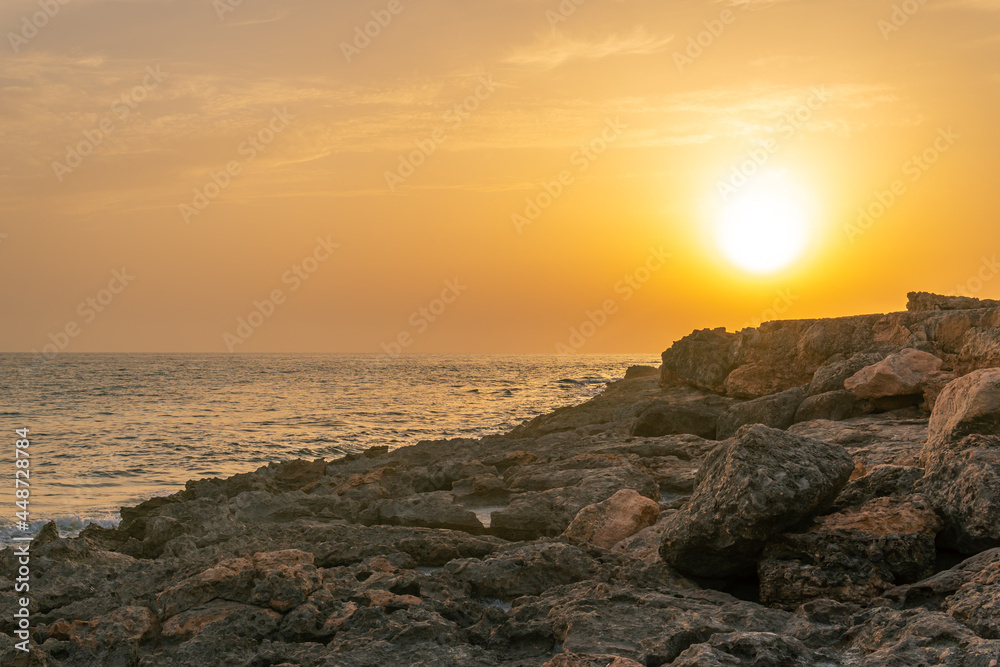 Rocky coast of the south of the island of Mallorca at sunset with the island of Cabrera in the background