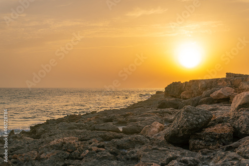 Rocky coast of the south of the island of Mallorca at sunset with the island of Cabrera in the background