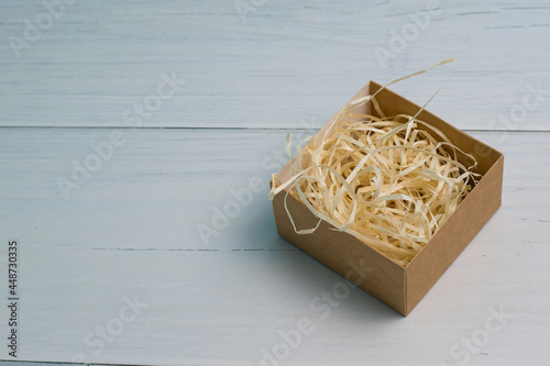 Craft gift box with light wood filler on wooden background with copy space © queen1987