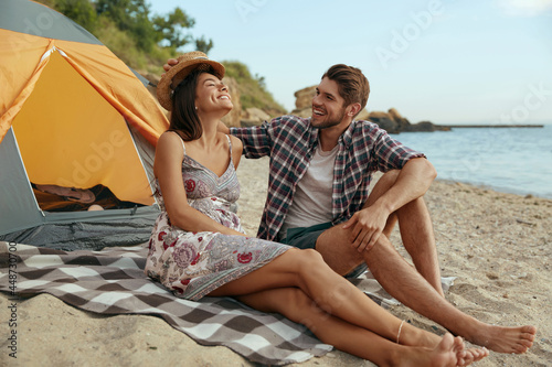 Young european couple resting on sandy sea beach