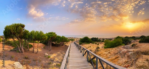 The gateway to La Barrosa beach at sunset in Cadiz, Spain photo