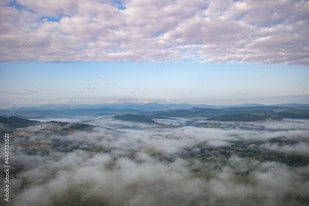 Obraz premium Aerial view on mountains in clouds from drone
