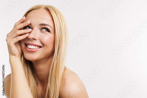 Half-naked blonde woman laughing and covering her face