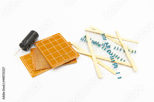 DIY Electronic Parts including capacitor, resistor, and perfboard isolated on white background photo