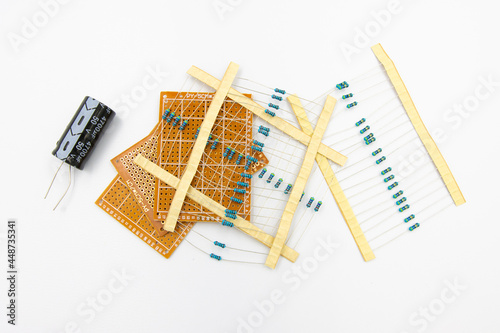 DIY Electronic Parts including capacitor, resistor, and perfboard isolated on white background photo