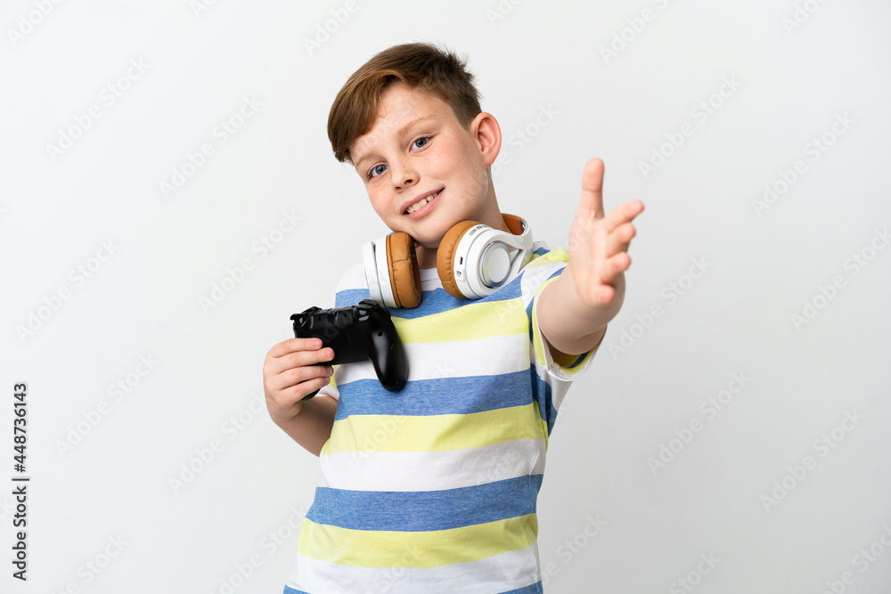 Little redhead boy holding a game pad isolated on white background shaking hands for closing a good deal Little redhead boy holding a game pad isolated on white background shaking hands for closing a good deal