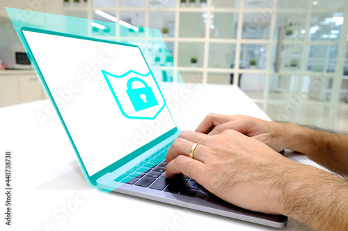 Businessman working on his laptop in the office, select the icon security on the virtual display. Protect computer concept.