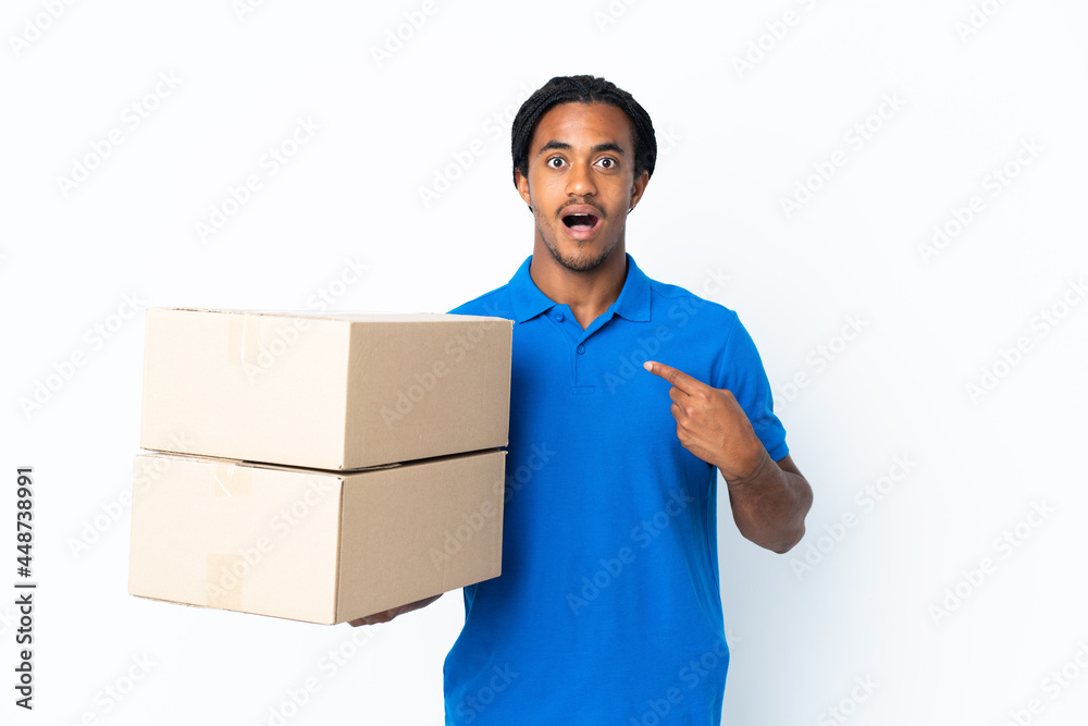 Delivery African American man with braids isolated on white background with surprise facial expression Delivery African American man with braids isolated on white background with surprise facial expression
