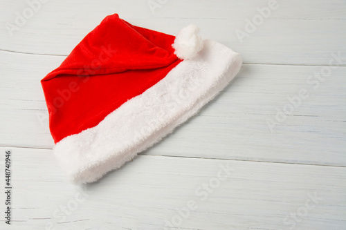Santa claus hat on a light wooden table close up copy space