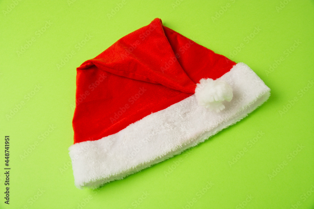 Santa claus hat on bright green background close up copy space Santa claus hat on bright green background close up copy space