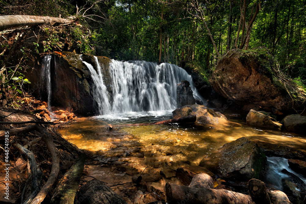 a large waterfall in a forest with sunlight a large waterfall in a forest with sunlight