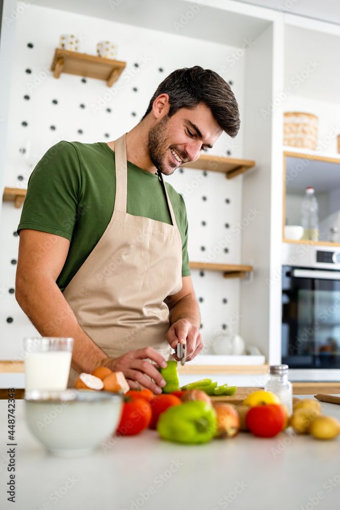 Happy caucasian man cooking in kitchen at home, smiling. Happy caucasian man cooking in kitchen at home, smiling.