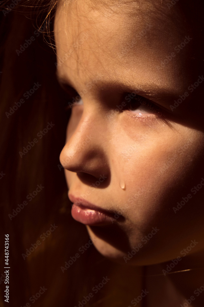 Dramatic portrait of sad little child girl with tear on the che Dramatic portrait of sad little child girl with tear on the che