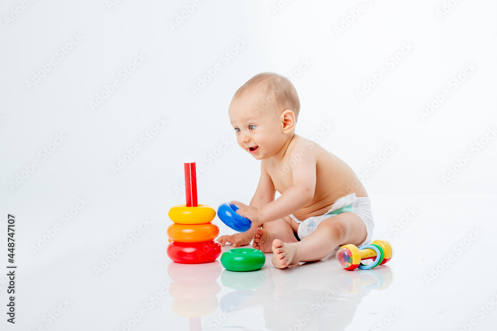 a baby boy with a multi-colored pyramid is isolated on a white background; a baby boy with a multi-colored pyramid is isolated on a white background;