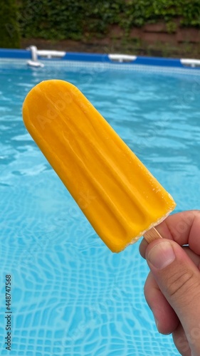 Gelbes Eis am Stiel im pool 