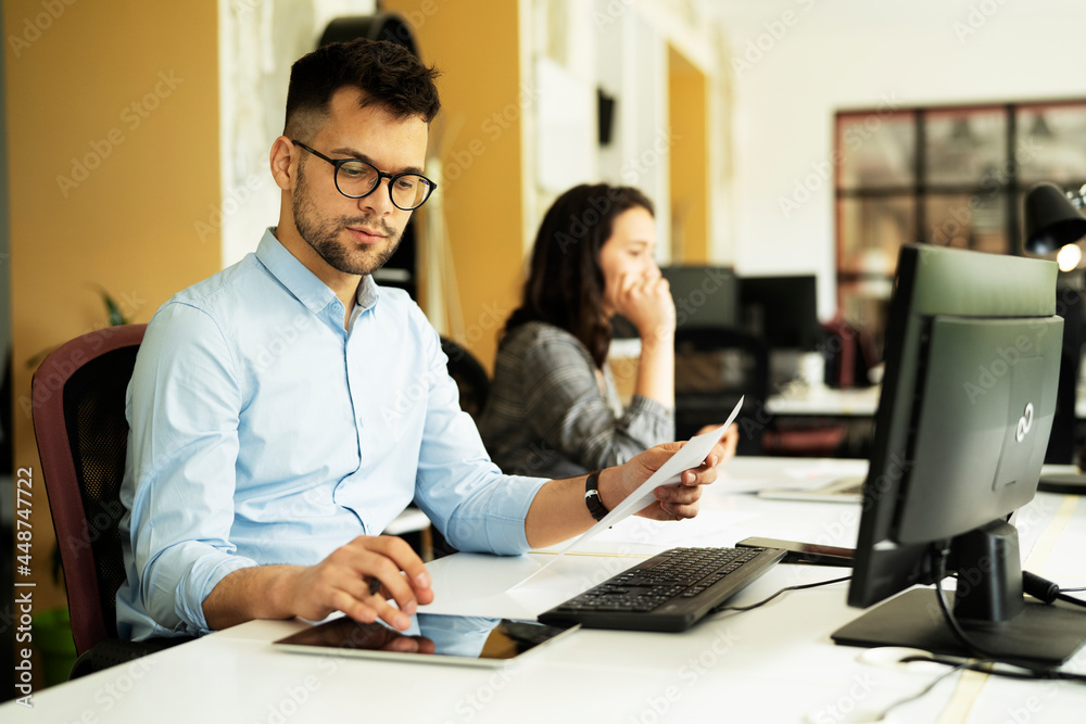Young businessman using laptop in his office. Handsome man working on laptop. Young businessman using laptop in his office. Handsome man working on laptop.