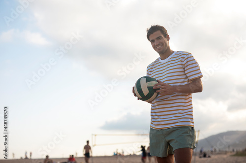 Fototapeta Naklejka Na Ścianę i Meble -  Young man with ball at the beach. Handsome man playing volleyball.