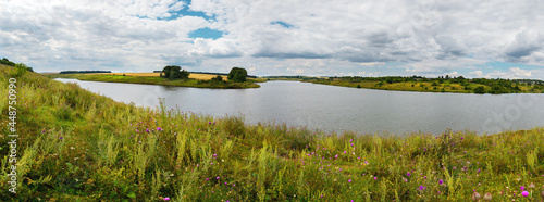 Summer landscape with river and cloudy sky