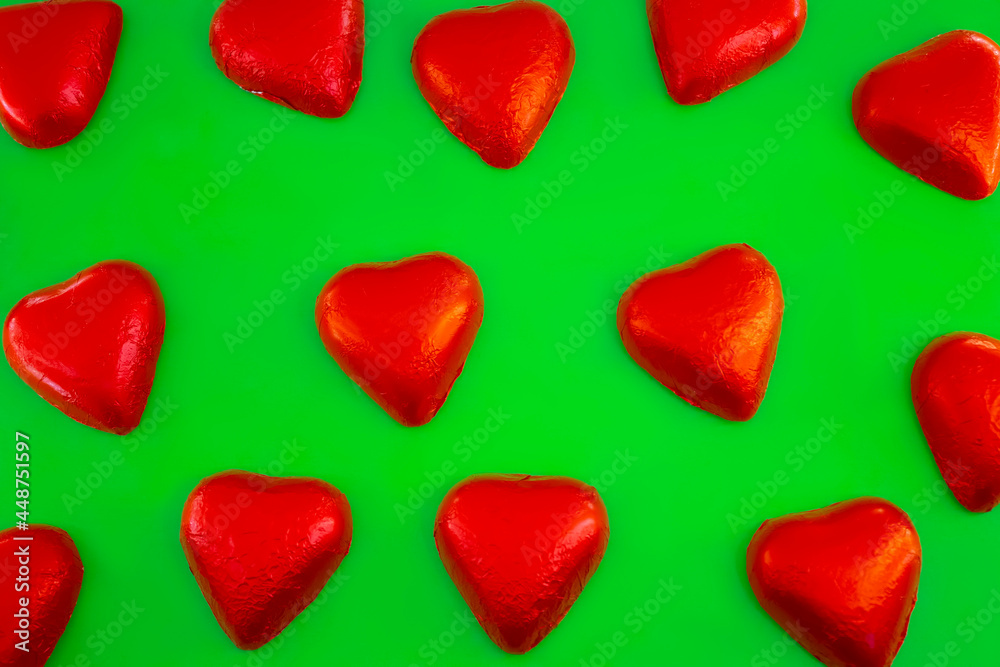 Chocolate candies shape of hearts on green background Chocolate candies shape of hearts on green background